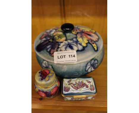 A Moorcroft pottery lidded vessel, together with two Moorcroft band branded enamel boxes 