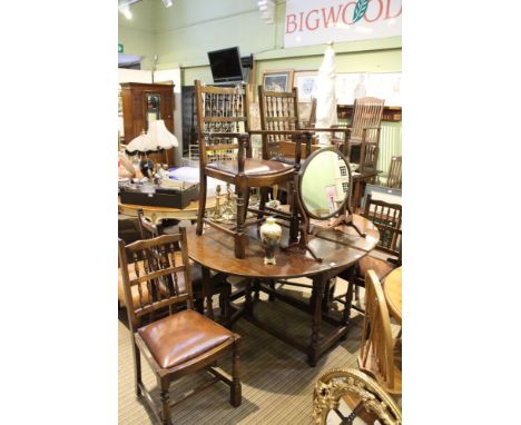 An early 19th century oak twin flap gateleg dining table on baluster and bobbin blocked legs with a box stretcher between 