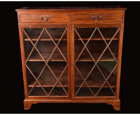 A 19th century mahogany bookcase, reeded slightly oversailing top above a pair of cockbeaded frieze drawers, and a pair of as