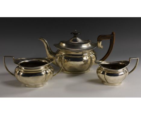 A George V silver three piece oval tea service, comprising teapot, milk jug and sugar basin, hinged cover with knop finial, a