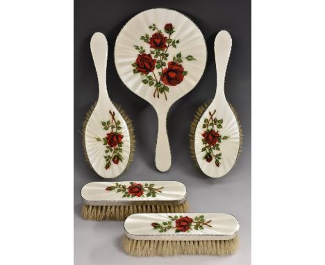 An Elizabeth II silver and enamel five piece dressing table set, comprising a hand mirror, a pair of hair brushes and a pair 