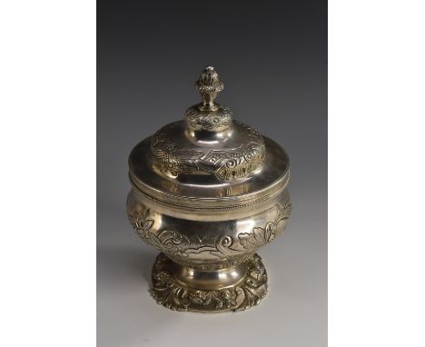 An early 19th century Portuguese silver pedestal sucrier, chased in the Rococo taste with bands of flowers and leafy scrolls,