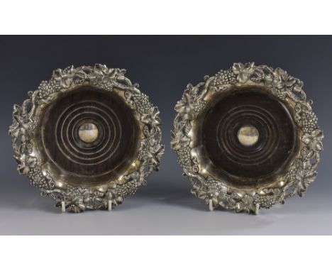 A pair of post-Regency Sheffield plate fluted shaped circular wine coasters, fruiting vine borders, draught-turned mahogany b