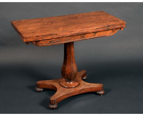 A William IV rounded rectangular rosewood card table, folding top enclosing a circular red baise-lined playing surface, panel