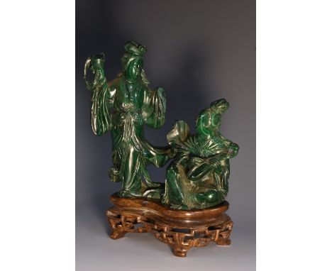 A Chinese malachite carving, of two courtly ladies, one stands proffering libation, the other seated playing a pipa, each wit