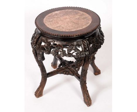 A late 19th century Chinese hardwood jardiniere stand, inset soapstone circular top, beaded border above friezes boldly carve