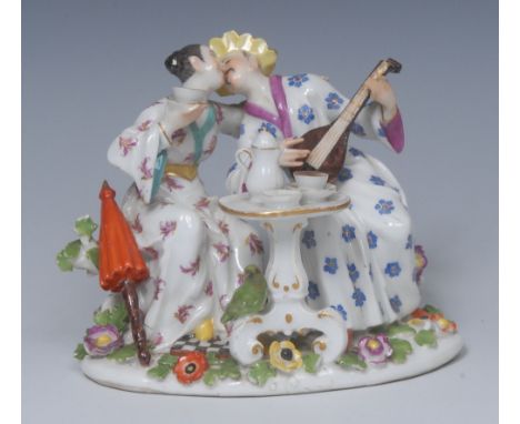 A Meissen figure group, The Chinese Lovers, modelled by P. Reincke, with a couple about to kiss, seated by a table, he with a