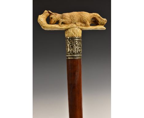 A Victorian silver-mounted ivory and malacca novelty walking stick, the T-shaped handle boldly carved as a fox hiding behind 