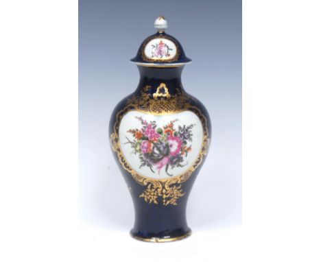 A Worcester baluster vase and cover, painted to front and verso with large bouquets of colourful flowers, reserved on a `wet 