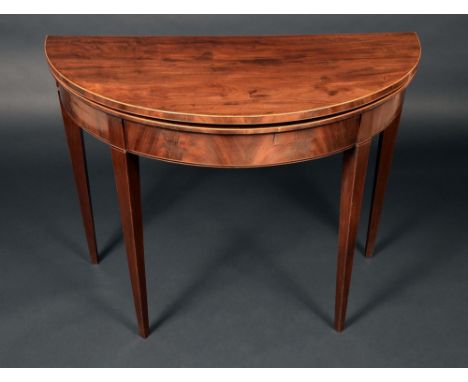 A George III mahogany demi-lune card table, folding top enclosing a baize-lined playing surface, outlined throughout with box