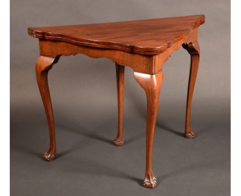 A George III design mahogany shaped tri-form card table, possibly Irish, folding top enclosing a baize-lined playing surface,