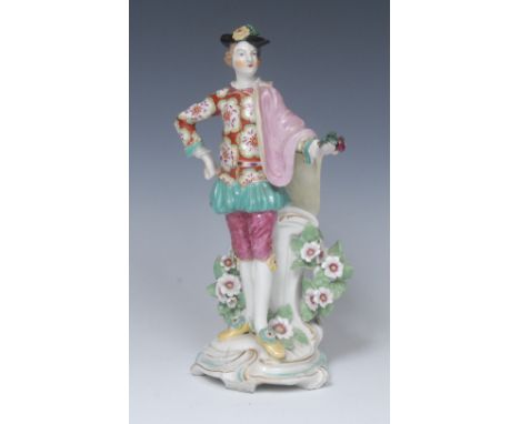 A Derby Patch Mark  figure,  of a  Ranelagh Dancer,  standing wearing a black hat, pink and yellow cloak, scroll base, 25.5cm