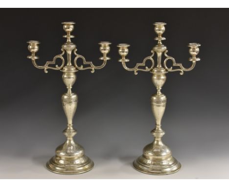 A pair of 19th century Austrian silver three-light table candelabra, urnular sconces, scroll branches, knopped baluster pilla