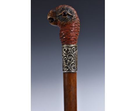 A late Victorian novelty silver-mounted softwood and malacca walking stick, the softwood pommel boldly carved as the head of 