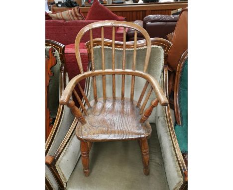 A 19th century child's elm Windsor armchair with stick back and solid seat, on turned legs 