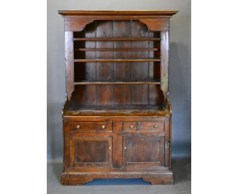 A George III Pine Dresser, the moulded cornice above a boarded shelf back, the lower section with two drawers and two cupboar