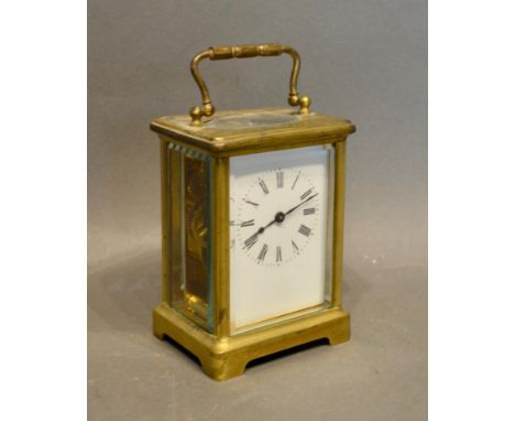 A French Brass Cased Carriage Clock, the enamel dial with Roman numerals and with lever escapement and carrying handle 