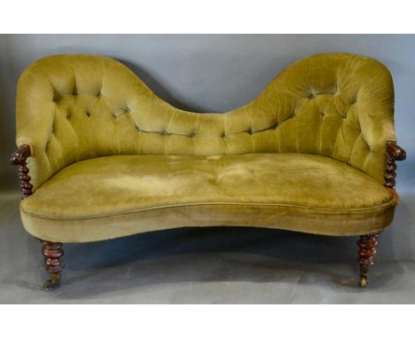 A Victorian Rosewood Double Spoonback Sofa with a button upholstered back above a stuff over seat with carved scroll arms rai