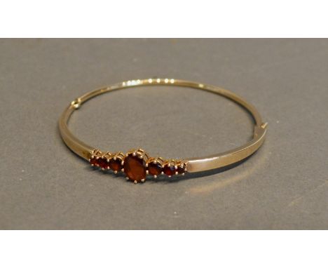 A 9 Carat Gold Bangle, set garnets, 8.9 grammes 