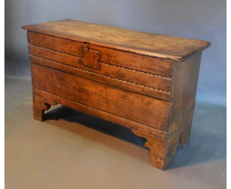 A George III Oak Coffer, the hinged top above a carved front raised upon bracket feet, 107cm wide, 41cm deep, 63cm high 