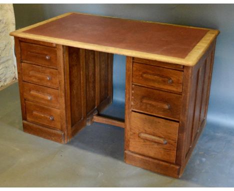 An Early 20th Century Twin Pedestal Desk, the leather inset top above seven drawers with cup handles, 127cm wide, 75cm deep, 