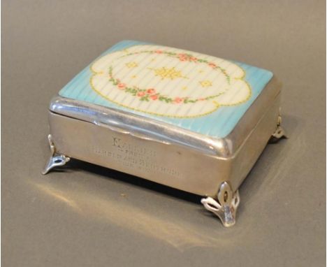 An Early 20th Century Silver Trinket Box, the hinged cover enamel decorated with bows and swags upon a pale blue and cream gr