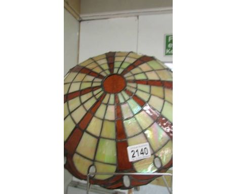 A Tiffany style uplighter lamp shade with chains.