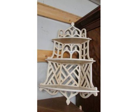 A painted fretwork corner shelf.