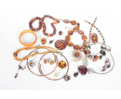 A Georg Jensen style amber and silver bracelet and pendant suiteTogether with various amber style beads, ear clips and remain