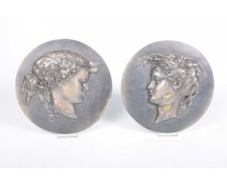 A pair of bronze uniface medallion plaquesEach of circular form modelled with classical male and female busts in mirror image