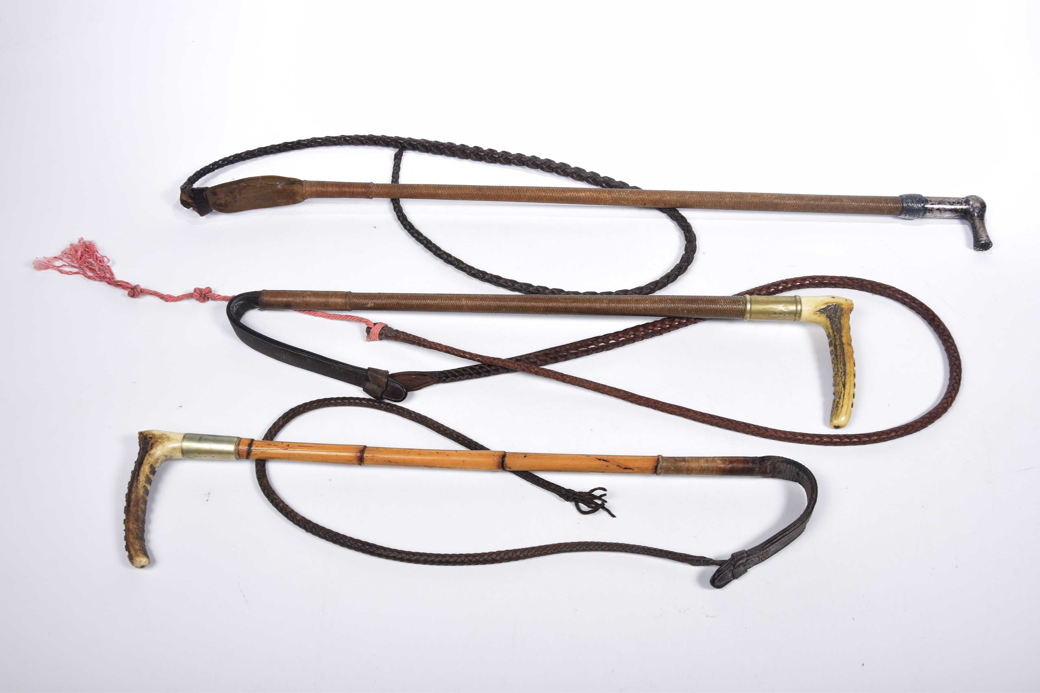 A collection of early to mid 20th Century hunting whips The first with