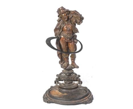 A Victorian cast iron figural stick standThe stand cast in the form of a reaper mounted above a " Reaper " name plaque with a