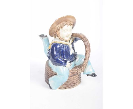 A Victorian Majolica 'Manx' novelty teapotThe teapot modelled as a three legged sailor seated on a coiled rope, the rope form