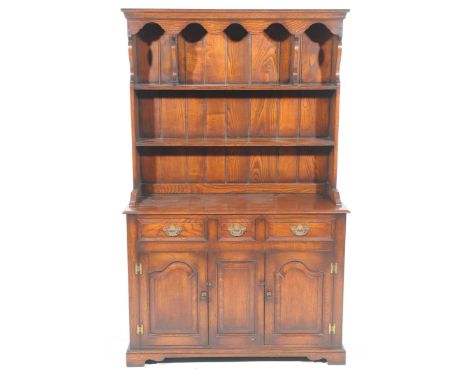 A reproduction Georgian style oak dresser by Connoisseur FurnitureThe high back with a moulded cornice and scalloped frieze a