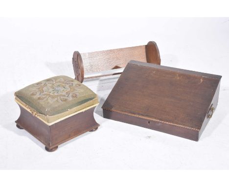 A 19th Century mahogany tabletop slope, an Arts and Crafts oak book trough and Victorian footstool The desk top slope with si