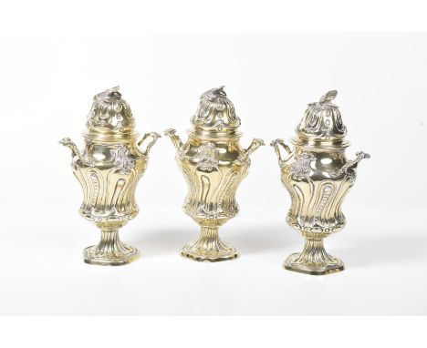An Edwardian matched set of three silver-gilt lidded cache potsOf knopped form, with embossed fluted decoration, with twin sc