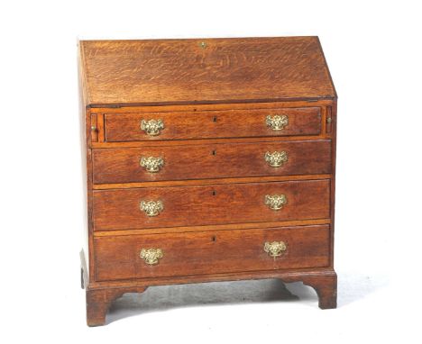 A George III oak bureauThe fall front enclosing a compartmentalized interior above four graduated long drawers each applied w