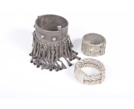 A collection of ethnic white metal African jewelleryComprising a twin rope twist and lock bangle, an wrist cuff with suspendi