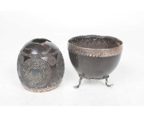 Two mid 19th Century carved coconut and white metal cupsThe first a half shell raised on three scroll supports adorned with t