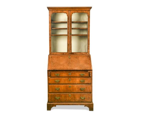 A walnut bureau bookcase, 18th century moulded top over two arched glazed doors, the fall front with fitted interior over fou