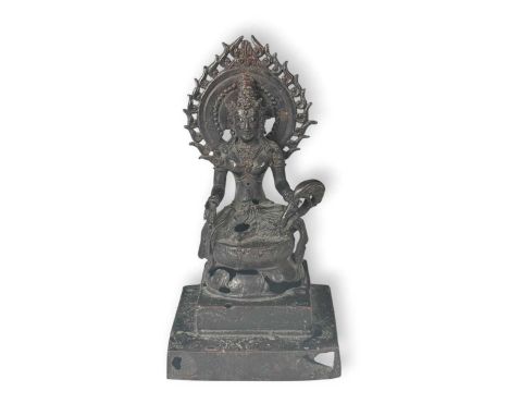 A Nepalese bronze Bodhisattva, 20th century, seated in meditation wearing robes and a crown, on a lotus dais backed by a flam