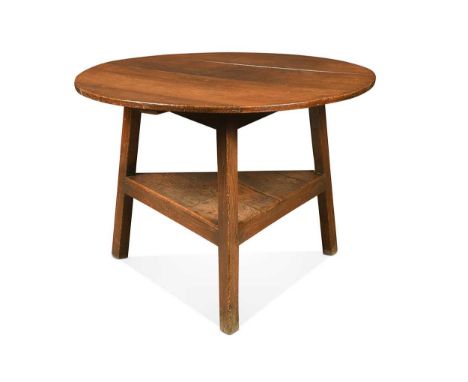 A large oak cricket table, 18th century, the four plank circular top on three legs united by a boarded shelf65 x 90cmProvenan