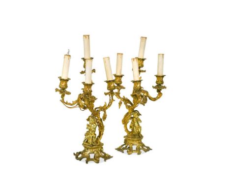 A pair of Rococo style ormolu three branch candelabra, late 19th century, each with four arms now wired for electricity, on c