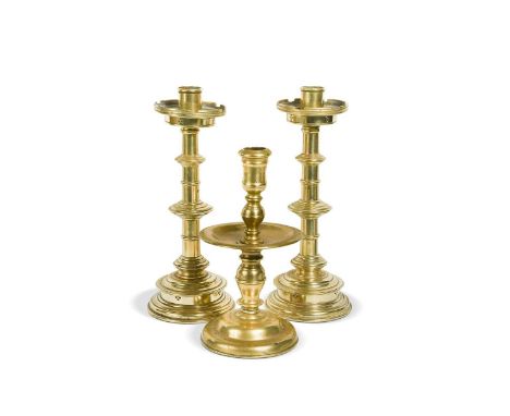 A pair brass table candlesticks,18th century, of knopped form with castellated sconces, 25cm high; together with a 17th centu