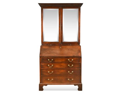 A George III mahogany bureau bookcase, the dental moulded cornice above a pair of mirrored cupboard doors and candle slides, 