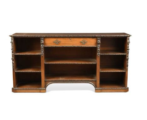 A mahogany bookcase, 19th century, the top with flower and ribbon carved edge over a single drawer and a combination of eight