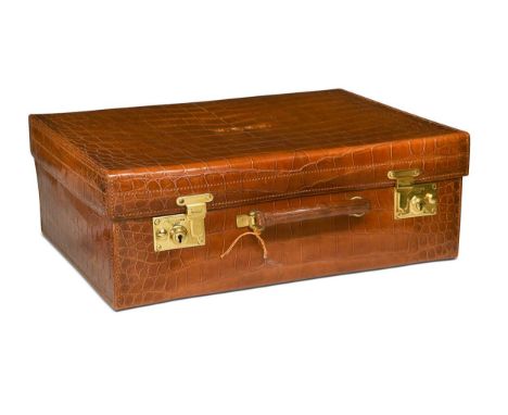 A crocodile leather travelling case by Goldsmiths & Silversmiths Co., London, with brass lock, stamped lett to the lid W. E. 