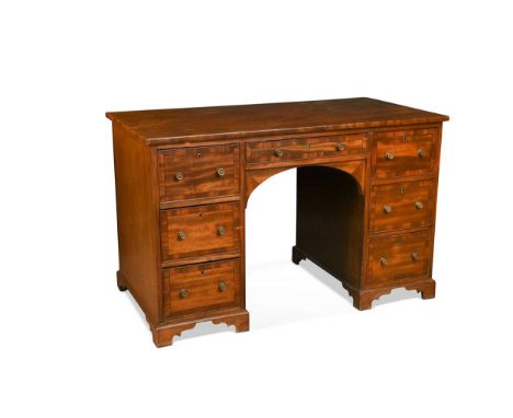 A mahogany knee hole desk, early 19th century, the rectangular top over seven crossbanded real drawers with opposing dummy dr