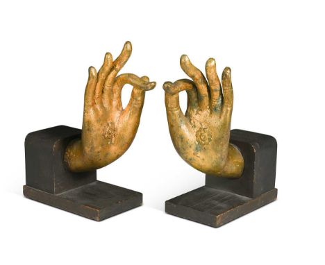 A pair of Tibetan gilt bronze Buddha hands, 19th century, the palms applied with florets, later mounted on wood and adapted a