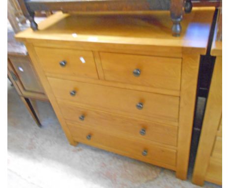 A 35 1/2" polished light oak and mixed wood chest of two short and three long drawers, set on block feet